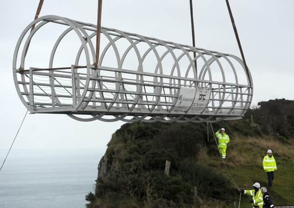 The tubular bridge section of the Gobbins cliff path is lowered into place.  INLT 44-676-CON
