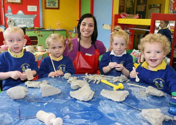 Mrs. S. McMullan with pupils of Ballymena Nursery playing with clay. INBT43-203AC