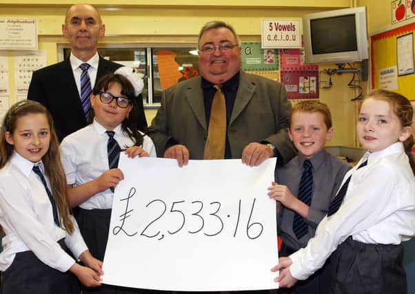 Mike Braithwaite of Action MS is pictured receiving a cheque for £2533.16 from Portglenone PS principal Mr. Robin McClintock and pupils Ruth, Milana, George and Abigail, who were the top fundraisers in the school. The huge amount was raised by the school taking part in a "Walk for MS" at the Ecos Centre. INBT44-203AC