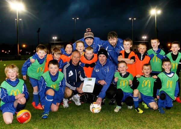 Wes Gregg is pictured presenting an IFA McDonalds Clubmark Programme 2014 Accreditation to Ali McGarry of Northend Youth as looking on are David Hendron, Gordon Patterson and members of the Under 9 squad. INBT44-201AC