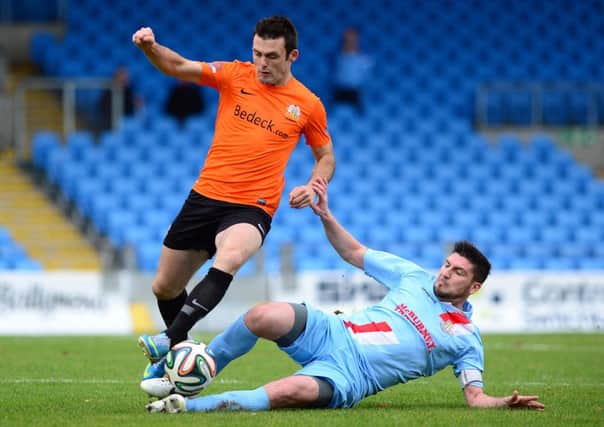 Davy Munster slides in to tackle Glenavon's Eoin Bradley during Saturday's match at the Showgrounds. Picture: Pacemaker Press.