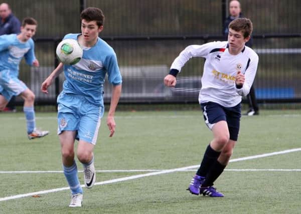 Ballymena U-16 and a Sion Swifts player chase the ball during their match. INBT44-217AC