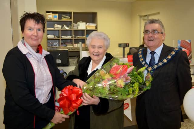 Breithne Mckillon and Mayor Charles Johnston prest Catherine McCartney with a bunch of flowers for opening the new Post Office branch in Victoria Euro Spar. INCT 44-118-GR