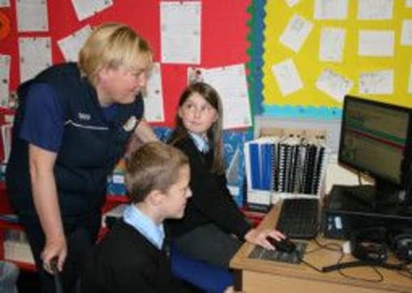 Edel Foy, Tescos Community Champion, is taught by Sophie Jones and Ryan Johnston how to use the Pupil Reward Points site.