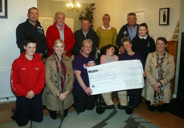 Jade and Debbie McAfee (front centre) present a cheque for £3545 to Northern Ireland Children's Hospice community fund-raiser, Catherine O'Hare, the proceeds of a charity climb of Knocklayde. Also included are - back row from left - Gordon McConaghie, Tom Christie, Robert Stewart, Shirley McKinley, Scenic Inn, Ivan King. Front row - Jake McAfee, Aimee King, Pamela and Leah McFetridge.Pic supplied. inbm45-14s