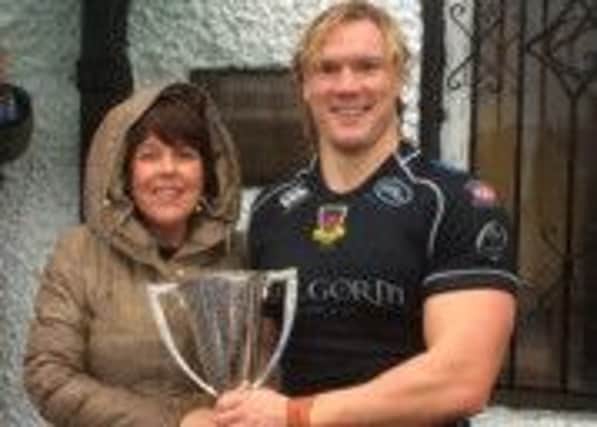 The Des Dempsey Memorial Trophy is presented by Dess daughter, Marita Costello, to Mike McComish, Ballymena captain, after the Eaton Park side's dramatic win in Saturday's All-Ireland League fixture.