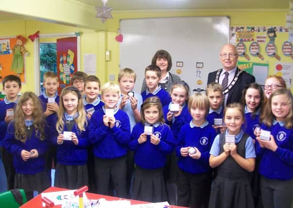 Ballymena Deputy Mayor, Cllr. Hubert Nicholl, presents Longstone Primary pupils with engraved clocks to celebrate the school's 110th anniversary.