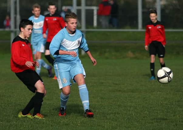Ballymena Youth U-15 player Ethan McKeown clears the ball from his Maiden City opponent. INBT45-258AC