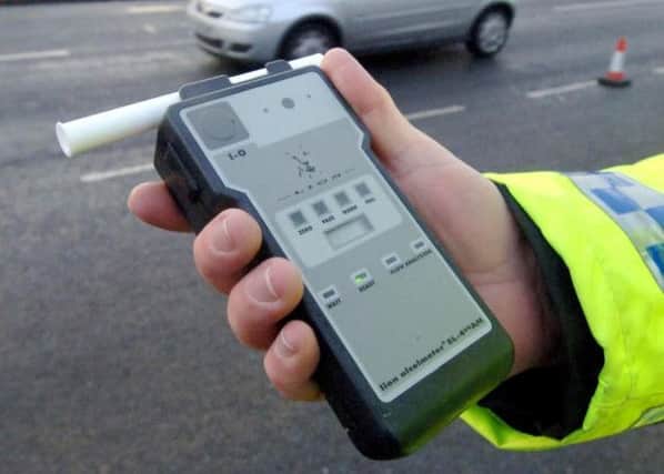 A police officer holding a breath test kit