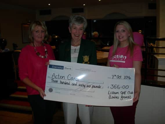 Lady Captain Mrs Gil Colvin presenting the cheque to Gillian Thomson from Action Cancer, with Liz Hill demonstrating the glamorous pink theme.