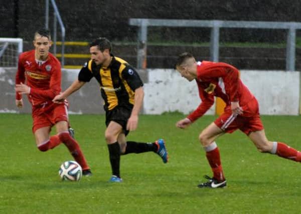 Carrick's Aaron Smyth breaks out of defence against Cliftonville Olympic.
