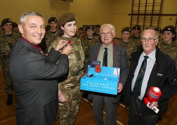 Phil Moffett of Cullybackey Royal British Legion pins a poppy on Lance Corporal Shonagh Nelson of Cullybackey Army Cadets while looking on are Legion members Major Bill Canning and John Foster. The Cullybackey branch called with the cadets to present them with poppies for their parade on Remembrance Sunday. INBT 46-103JC