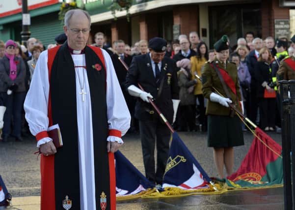 The Rt Reverend Ken Good, Bishop of Derry & Raphoe, observes a minutes silence at the Londonderry War Memorial.