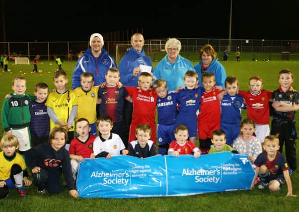 John Devlin of Northend Youth Football Club presents a cheque for £500 to Margaret Gourney and Sandra Rainey of the Alzheimer's Society, money he raised by running the Belfast Marathon. Included is coach Alex McDonald and members of the U-8 squad. INBT45-200AC