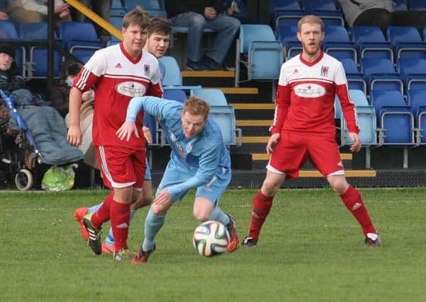 Wakehurst goalscorer Corey Price (left) challenges a Portstewart opponent as team-mate Owen Gregg looks on.