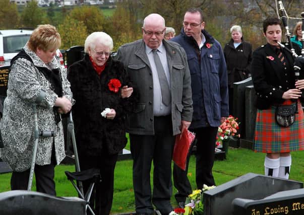 Mrs. Blanch Cross, with her sons Vance, Harry and Robbie and daughter Sharon, by the graveside of her son Winston, marking the 40th anniversary when he was murdered by IRA terrorists. INLS 4614-2402MT.