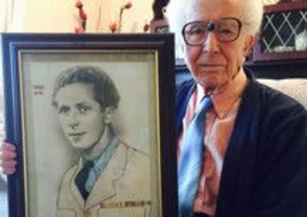 WWII veteran Joe Campbell with a picture of himself in his RAF uniform in 1946