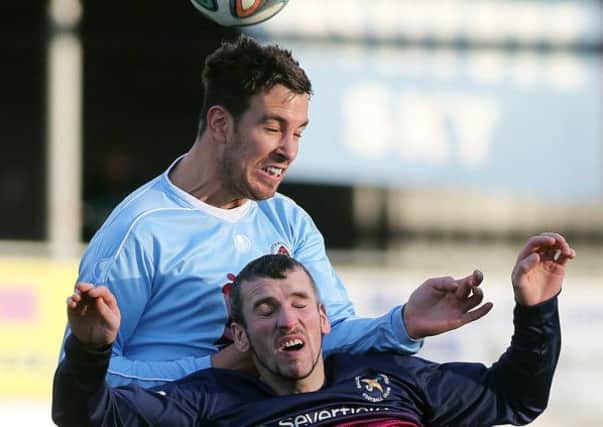 Institute's Mark Scoltock out-jumps Ballinmallard United striker Ryan Campbell. Picture by Lorcan Doherty/Presseye.com