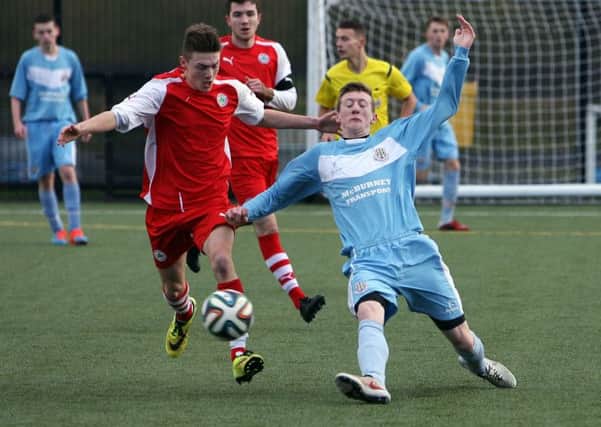 Ballymena's Leon Bones manages to kick the ball away from his Cliftonville opponent during their match at Ballymena Showgrounds. INBT47-249AC