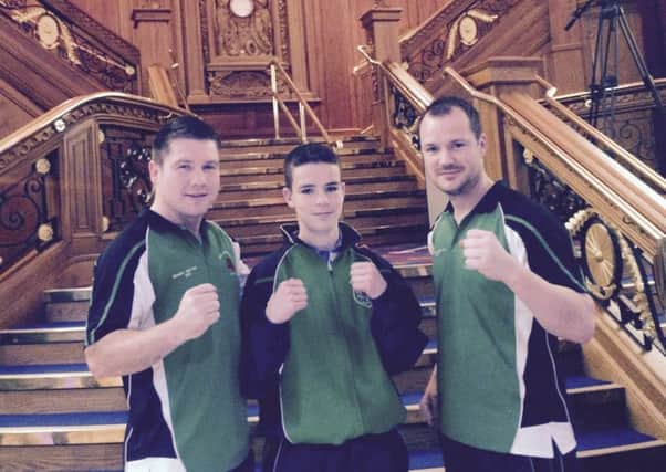 All Saints Boxing Club boxer Tom Stokes pictured with coaches TJ and Dermot Hamill at Belfast's Titanic Building, where he competed against an American opponent.