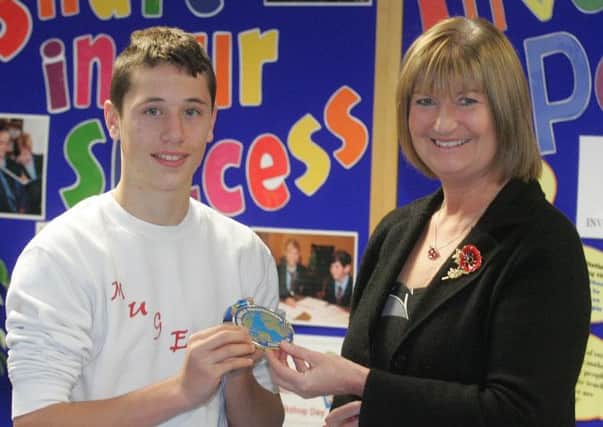 Downshire School pupil Bradley Beck shows his kickboxing gold medal to principal Mrs Jacqueline Stewart. INLT 47-920-CON