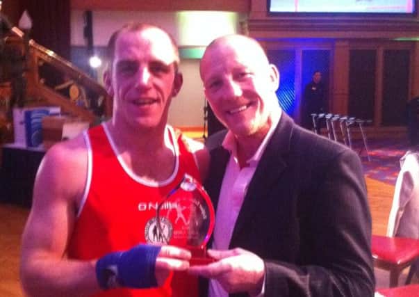 Braid ABC boxer Chris Richmond receives his trophy from former Commonwealth champion Eamonn Magee after his victory in the Belfast-Beltway event in Belfast last week.