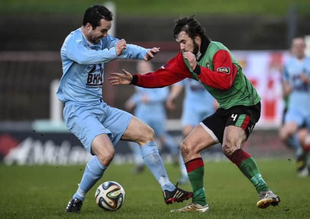 Glentoran's Fra McCaffrey tries to get away from Institute midfielder Mark Forker during Saturday's game at the Oval. Picture by Russell Pritchard/Presseye