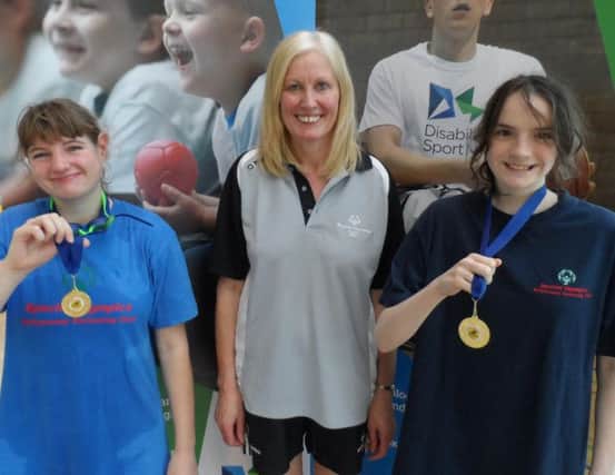 Catherine Park and Megan Fleming from Ballymoney Special Olympics Club pictured with coach Sally Martin at the Disability Sport NI Open Swim Championships