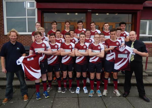 Carrickfergus Grammar School's 1st XV with sponsors Rory Moore (Carrick Marine Projects) and Paul Stirling (R&J Family Butchers).