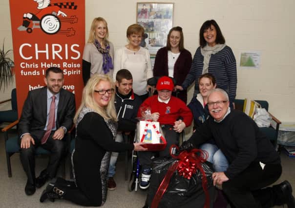 Gerry and Geraldine McCollum of The Christopher McCollum Fund pictured presenting gifts to Tiernon McCartney, a pupil of Ballysally Primary School. Included are; James Caldwell (father), Joeleen McCartney (mother), Isobel Douglas (Neuro Nurse NI), Tracey McMullan (granny), Jane McCafferty (class assistant), and Lynne Anderson (teacher). INCR48-325PL