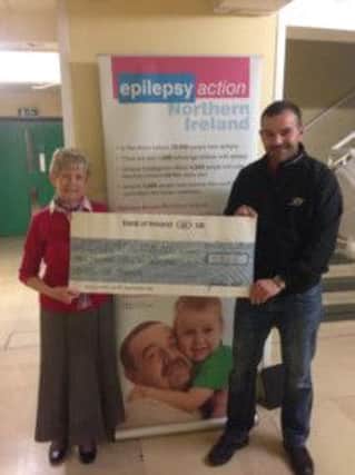 Marina Clarke from Epilepsy Action Northern Ireland receives the fundraising cheque from Jonathan Scott.