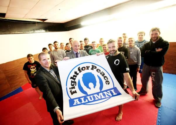 (L-R) Chris Quinn, Alderman John Blair and Danny Corr with participants from the Fight for Peace programme at the Dojo in Mallusk. INNT-49-701-con