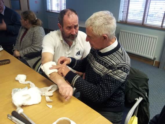 Belfast Lough Saillability volunteer Bill Foster giving first aid to BLS instructor Colin Craig. The course was held courtesy of Carrickfergus Marina (photo by Iain McAllister). INCT 49-707-CON SAIL