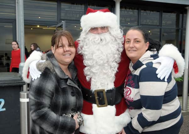 Getting a hug from Santa at Larne Market Yard are, Louise Todd and Michelle Lynn INLT 50-245-AM