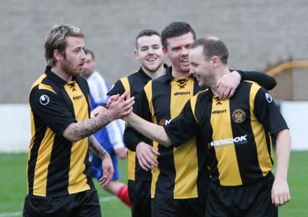 Veteran striker Graeme Arthur is congratulated by his Carrick team-mates after he netted Rangers' fourth goal on Saturday.