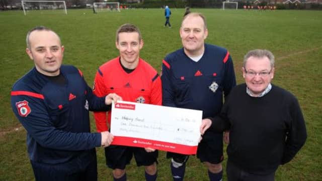 Referees Chris Budd, Mark Fenton and Paul Smyth hand over a cheque on behalf of Lisburn League referees to Nigel Kearney from the Helping Hand charity. The referees raised £1,230 by handing over their match fees during the last two weeks. US145027cd  Picture: Cliff Donaldson