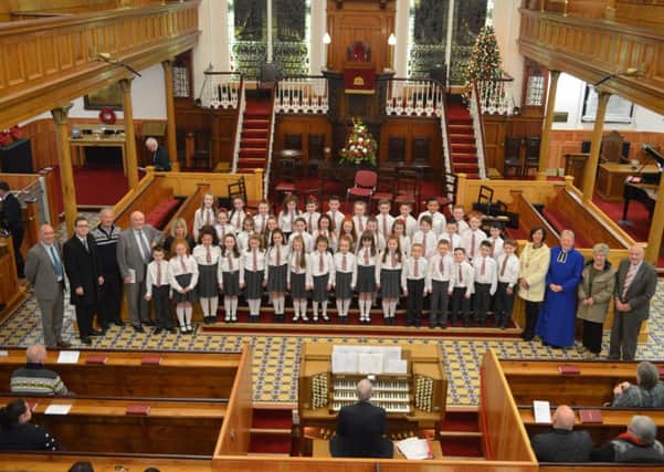 The Holy Family Primary School choir, with Principal Mr Gary Matheson and musical director Mrs Doherty pictured with the Mayor Brenda Stevenson, Deputy Mayor Gary Middleton, clergy and event organisers.