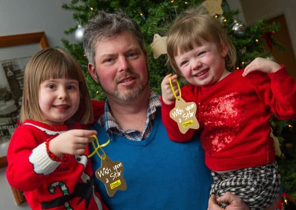 Richard Hood and his daughters Rebekah (5) and Megan (2) from Ahoghill are launching Friends of the Cancer Centres Wish Upon a Star appeal, which will see the Cancer Centres Christmas tree adorned with hundreds of gold stars, each carrying the personal wish, message or name of a loved one affected by cancer.