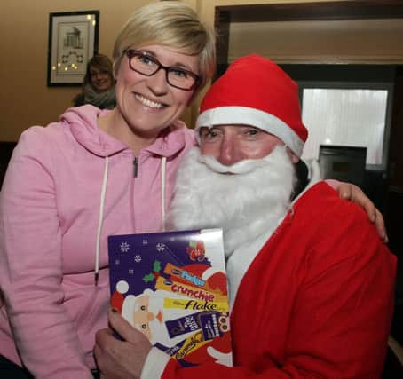 I'VE BEEN A GOOD GIRL. It looks like Katie Speers is getting a gift from Santa Claus, who took time out from his busy schedule to drop in at Ballymoney RFC on Saturday morning where he handed out gifts to the Mini and Maxis.INBM51-14 117SC.
