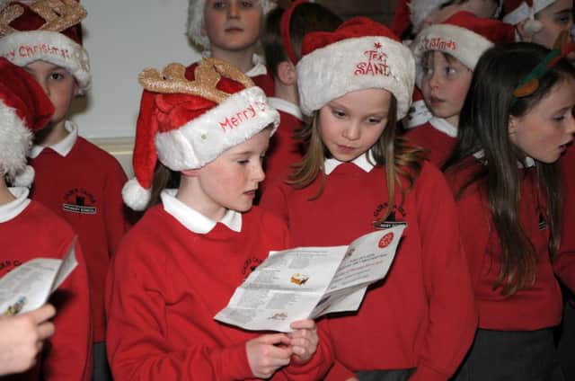 Pupils from Cairncastle PS sing carols around the Port of Larne Christmas Tree INLT 51-223-AM