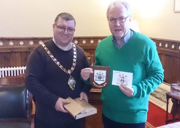 Mayor Martin Wilson presents Larne Wallison with a plaque during his visit to the town.