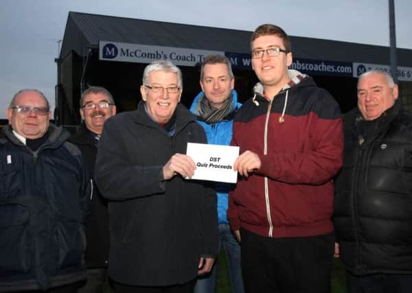 Michael Bell, chairman of the Distillery Supporters Trust (DST), along with other members of the DST presents  Lisburn Distillery chairman Jim Greer (centre left) and vice-chairman Rodney McComber (right) with the proceeds from their recent successful quiz night. Picture - David Hunter.