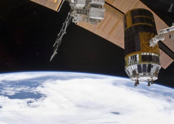 This image provided by NASA shows the Japanese Kounotori2 H-II Transfer Vehicle In the grasp of the International Space Station's Canadarm2, being relocated from the Harmony node lower port to Harmony's upper port Friday Feb. 18, 2011. A cloud-covered part of Earth and the blackness of space provide the backdrop for the scene. (AP photo/NASA)