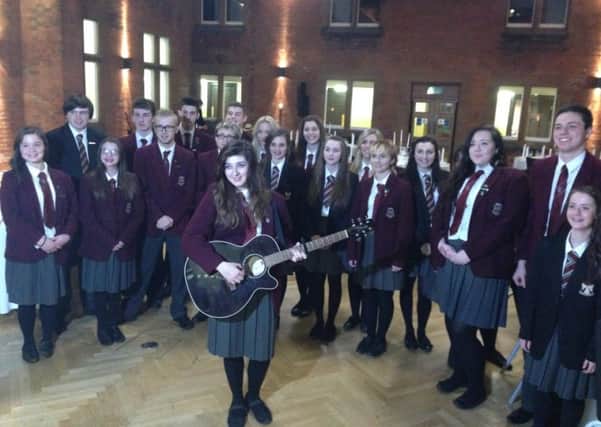 Lauren Craig (centre, with guitar) with the school choir.  INCT 52-724-CON