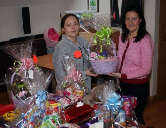 Aideen McMullan (right) with one of the many hampers to be distributed to families in the Cloughmills area before Christmas. The gifts are from the Millside Restaurant whose representative, Stephanie Gray, is pictured making the presentation. INBM52-14S