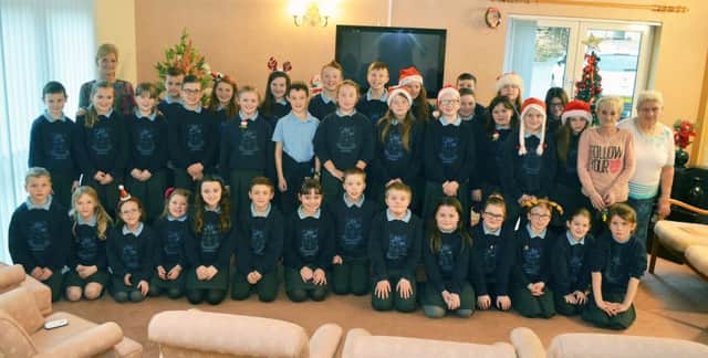 Residents of Gloonan House, Ahoghill; join the Fourtowns Primary School choir and orchestra last week where the pupils sang carols at the home. INBT 52-808H
