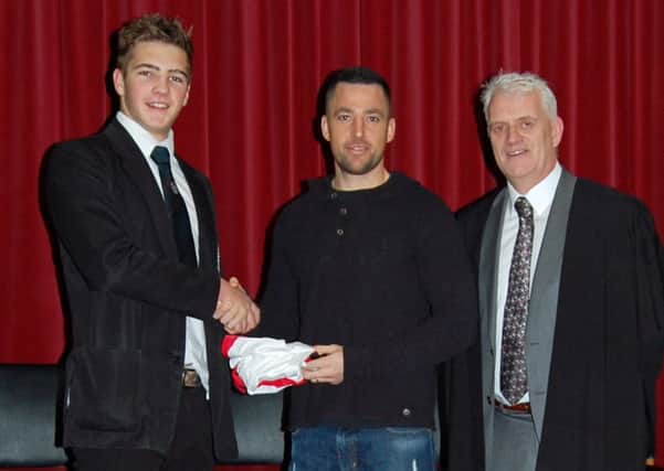 In Humphreys presents Ballymena Academy's Marcus Rea with his Ulster Schools shirt. Looking on is principal Mr Stephen Black.