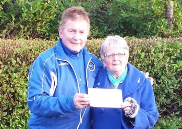 Moira McAuley, one of the prizewinners in the Northend United Youth FC Christmas draw, receives her prize from club chairman Johnny Sayers.