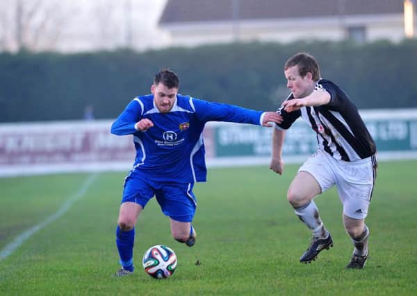 Coagh's William Ferguson holds off a challenge from a Wakehurst defender during Saturday's league encounter at Hagan Park.INMM5214-438