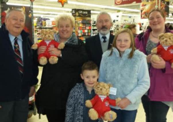RAFA Members Kevin McRandle and Joe Corr present Red Teds to Marion Hamilton (left), Jack McCreedy and Jackie Pollock (right) at the Sainsbury's bag pack on December 23.  INCT 01-730-CON